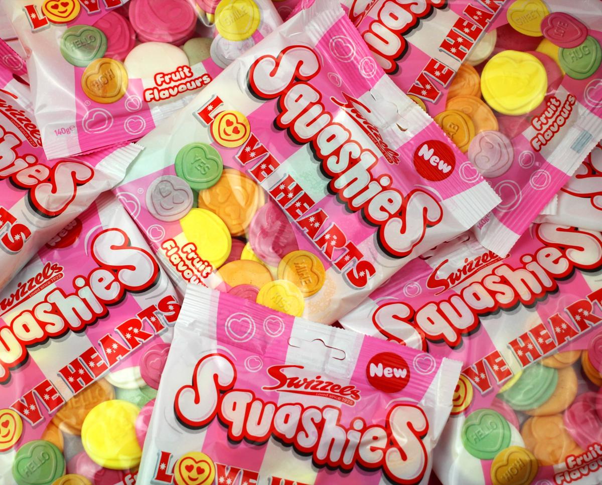 Pile of Squashies candy packages with colorful gummy hearts.