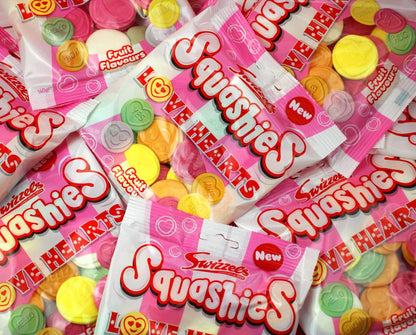 Pile of Squashies candy packages with colorful gummy hearts.