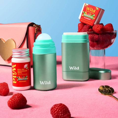 Two green containers labeled 'Wild' with raspberry products on a pink and blue background.