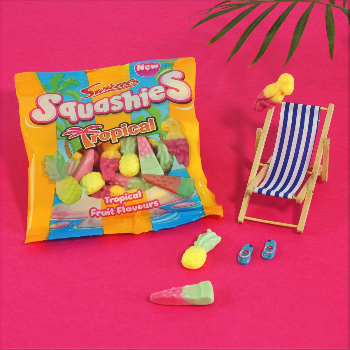Squashies Tropical fruit-flavored gummy package with gummies on a pink background