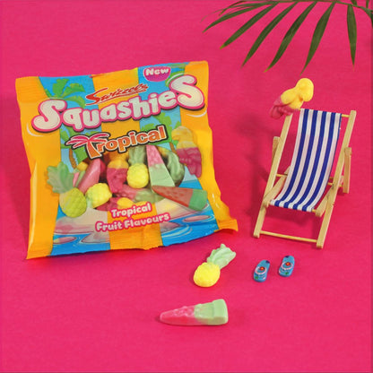 Squashies Tropical fruit-flavored gummy package with gummies on a pink background