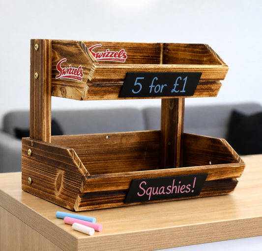 Wooden display stand with 'Swizzles' branding and chalkboard labels on a wooden surface.