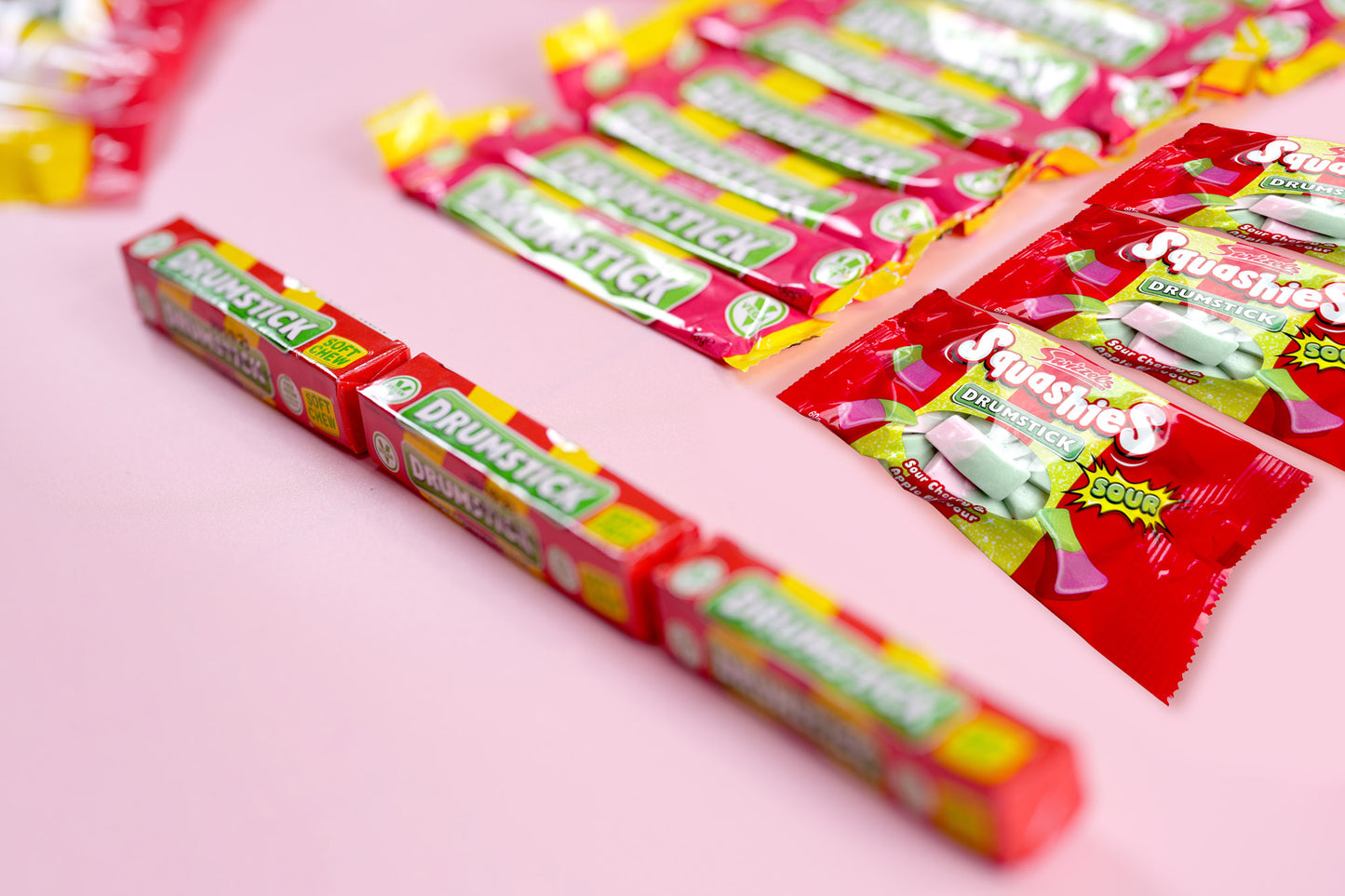 Several red and yellow Dr. Dreisick Menthol 1000 gum sticks and single packets arranged on a light pink background.