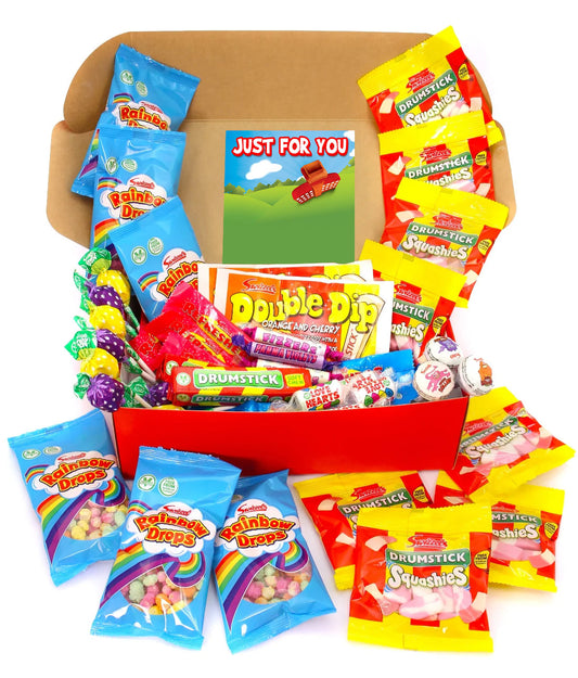 A children's candy gift box filled with assorted packaged sweets, lollipops, and a small card reading 'JUST FOR YOU.' The box is open and surrounded by colorful candy bags, including Rainbow Drops, Double Dip, and Drumstick brands, on a plain white background.